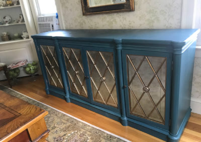 blue green painted console with gold accents